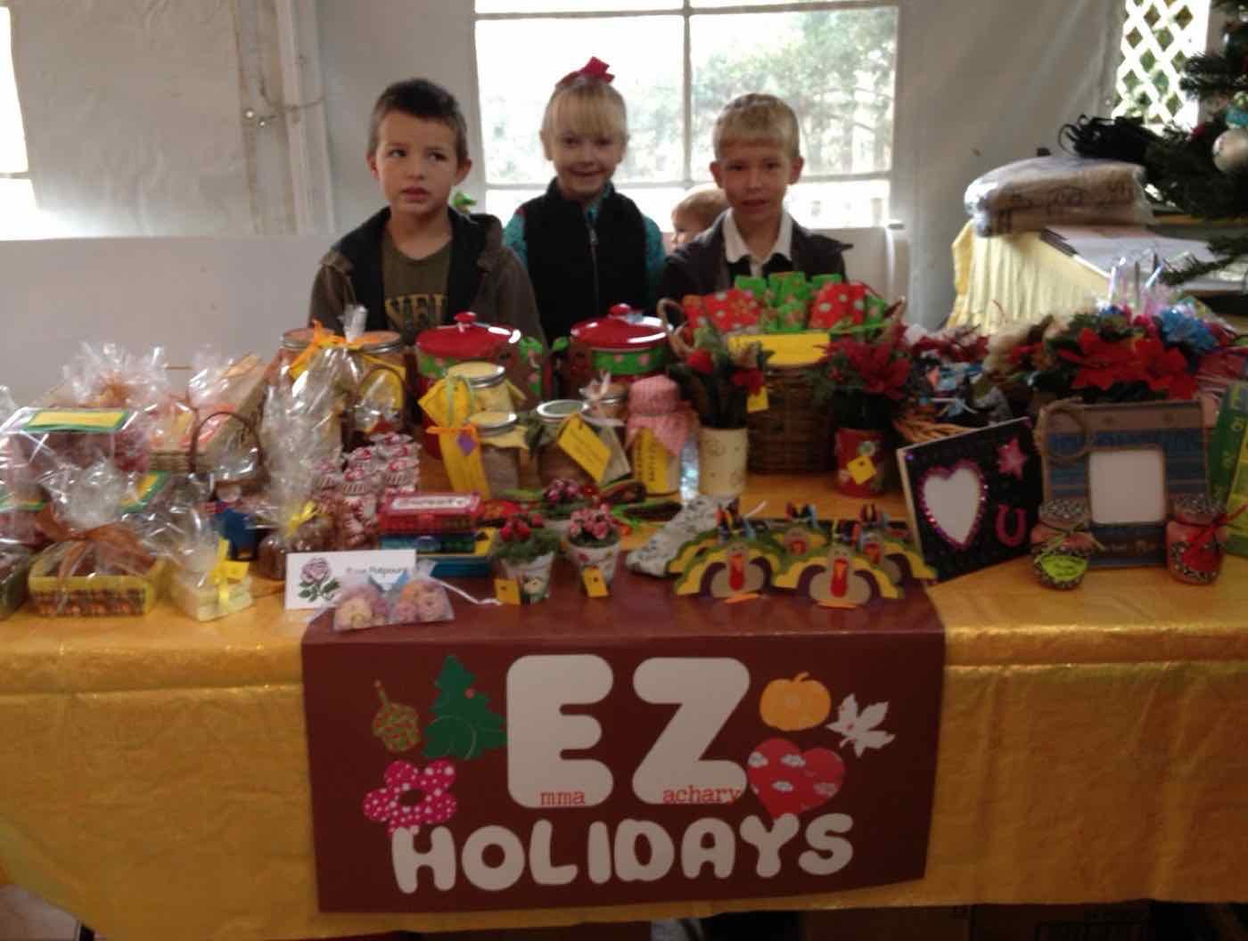 Zachary and his cousins behind the EZ Holidays table of crafts and baked goods