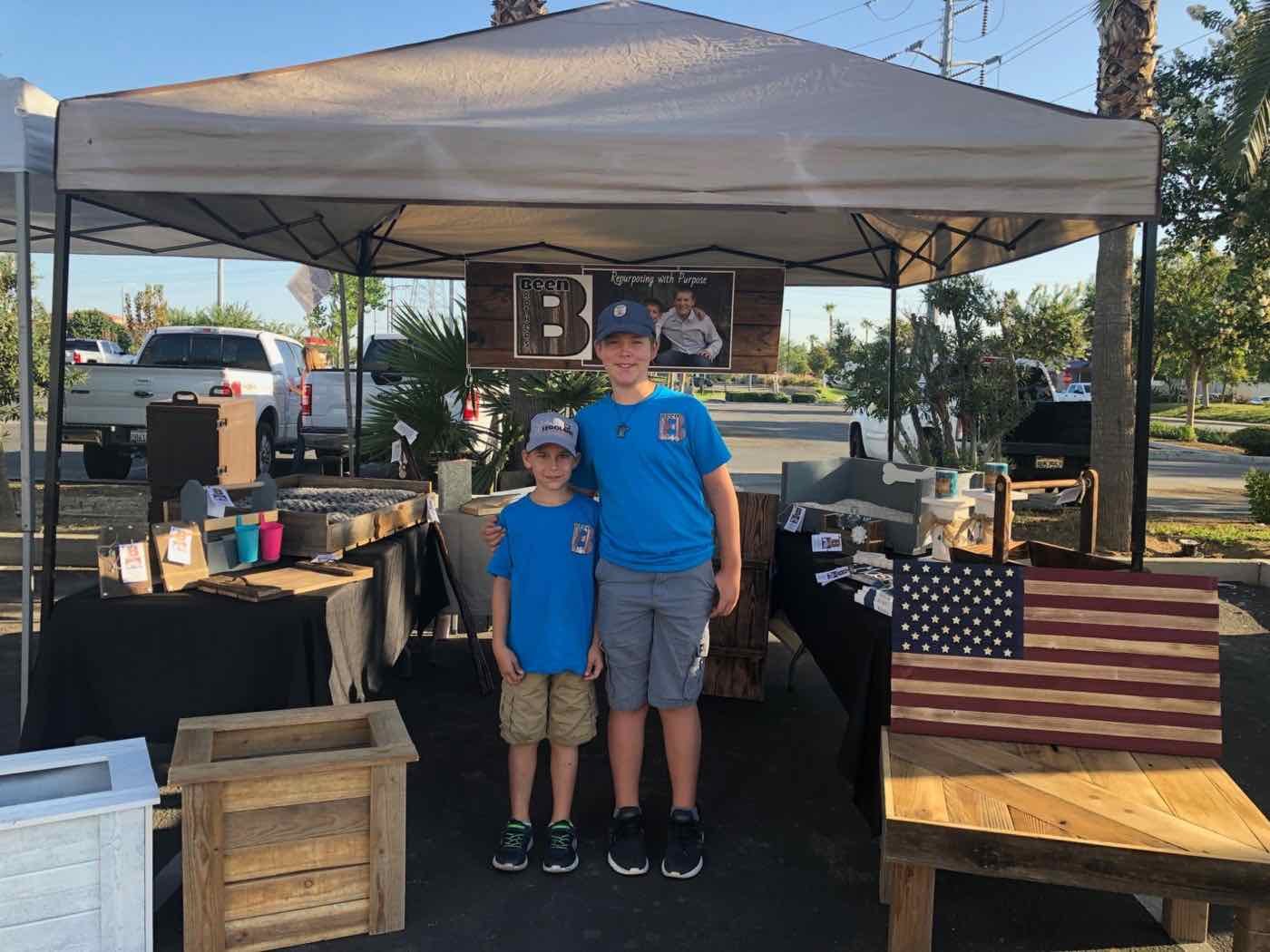 Blake and Zachary in matching shirts at their Been Brothers farmers' market booth