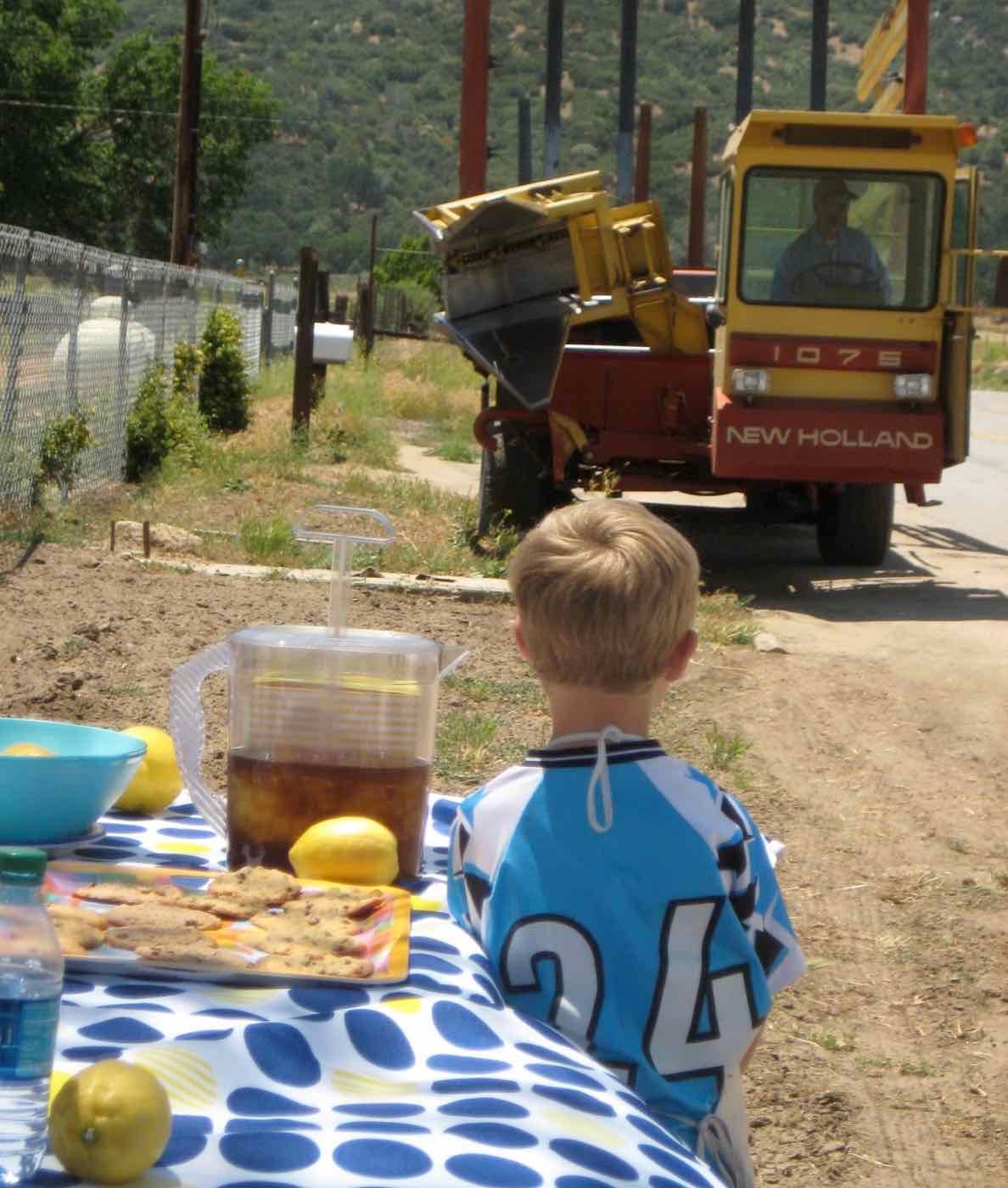 A harrow-bed tractor pulled up at the lemonade stand