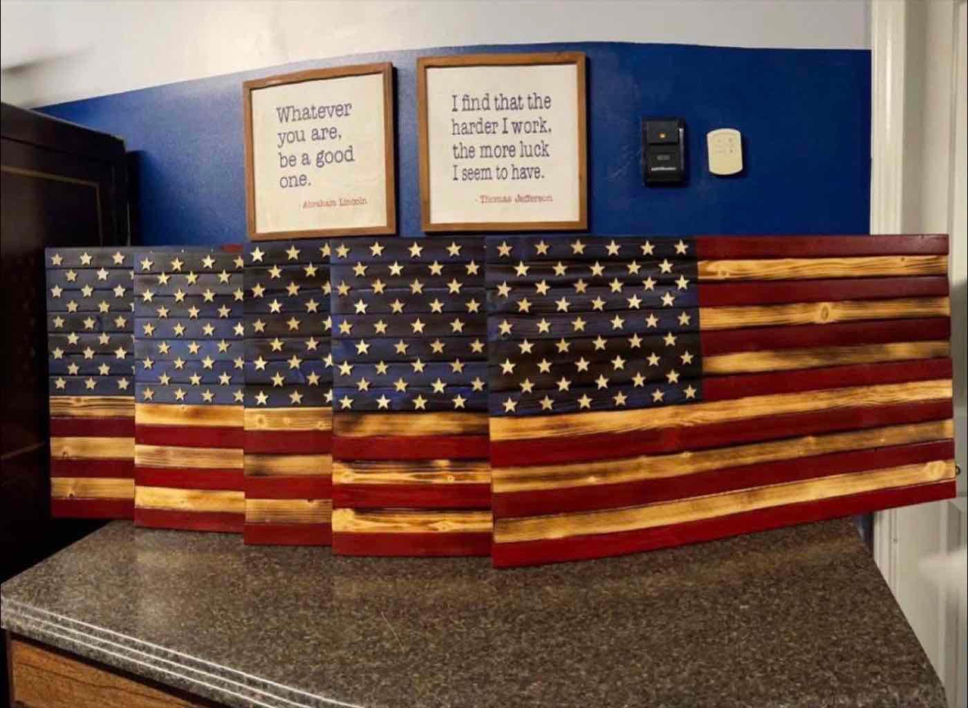 Five handmade wooden American flags with burned wood stripes and carved stars